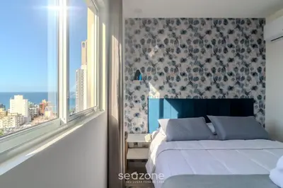 Uma cama ou camas num quarto em Apto 2Q c/ Churrasq. e vista 550m da Praia OMC1303