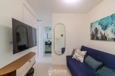 Uma televisão e/ou sistema de entretenimento em Apto 2Q c/ Churrasq. e vista 550m da Praia OMC1303