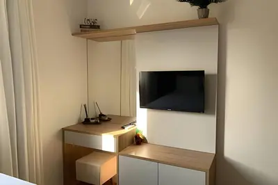 Uma televisão e/ou sistema de entretenimento em Apto Térreo com Garden | A/C e Churrasqueira