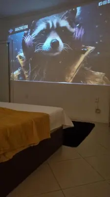 Uma cama ou camas num quarto em Suíte Master, Ar cond, Tela Cinema 150