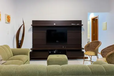 Uma televisão e/ou sistema de entretenimento em Amplo apartamento há 150 metros do mar na Praia de Palmas! 0318