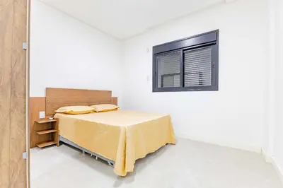 Uma cama ou camas num quarto em Apartamento a 150 Metros da Praia com Piscina
