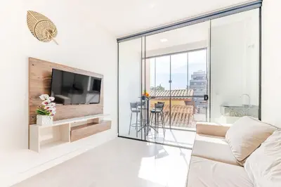 Uma televisão e/ou sistema de entretenimento em Apartamento a 150 Metros da Praia com Piscina