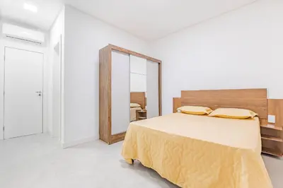 Uma cama ou camas num quarto em Apartamento a 150 Metros da Praia com Piscina