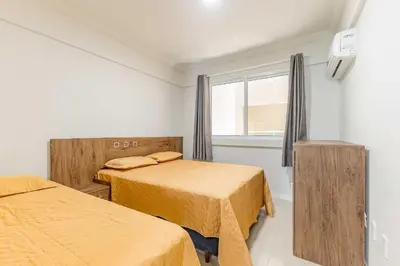 Uma cama ou camas num quarto em Apto em Bombas: Confortável e Econômico
