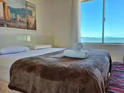 Uma cama ou camas num quarto em Vista Incrível Frente Mar 2 Quartos |CURTA134