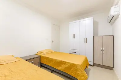 Uma cama ou camas num quarto em Confortável e Econômico: Apartamento em Bombas