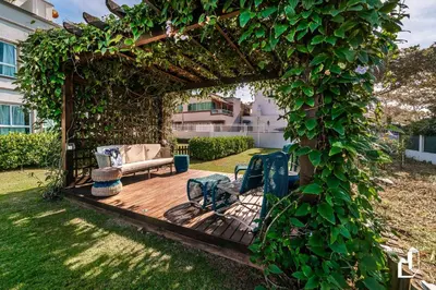 Um jardim no exterior de Condomínio com piscina e saída direta para a praia