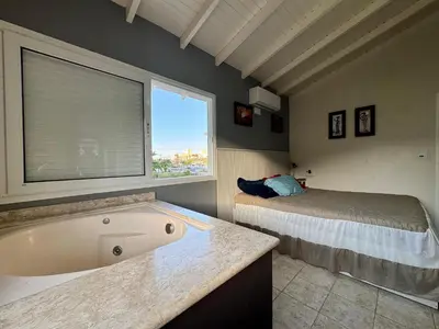 Uma cama ou camas num quarto em CASA PINHEIROS - Casa na Praia de Palmas com 4 Dormitórios e Piscina