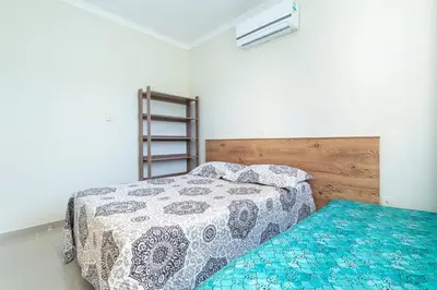 Uma cama ou camas num quarto em Apartamento Bombinhas próximo à praia