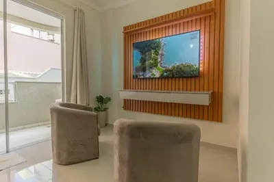 Uma televisão e/ou sistema de entretenimento em Apartamento Bombinhas próximo à praia
