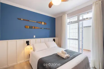 Uma cama ou camas num quarto em Apto c/ varanda e churrasq. a 30m do Mar RDM0101
