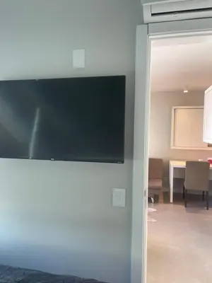 Uma televisão e/ou sistema de entretenimento em Apê de fundos em condo beira mar com garagem e Wi-Fi