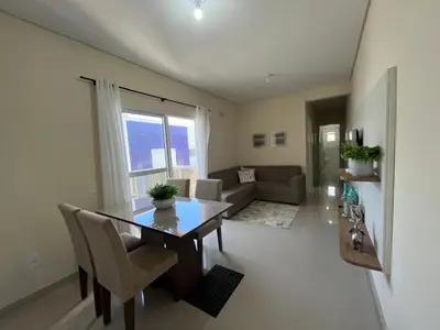 Uma área de estar em Lindo apto com piscina e churrasqueira a 400m da praia!