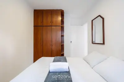 Uma cama ou camas num quarto em Apto c/ varanda e churrasq. a 290m do mar CAU0199