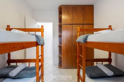 Uma cama ou camas num quarto em Apto c/ varanda e churrasq. a 290m do mar CAU0199