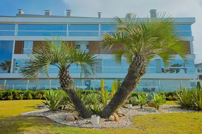 Um jardim no exterior de Condomínio Frente Mar com Piscina