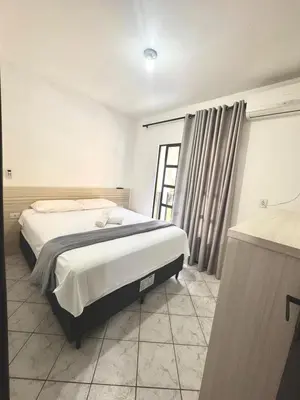 Uma cama ou camas num quarto em Casa no centro de bombinhas, SC