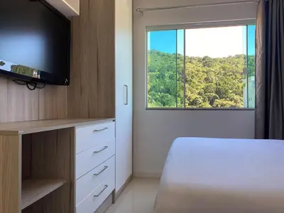 Uma televisão e/ou sistema de entretenimento em Bombinhas, seu refugio com vista para a natureza