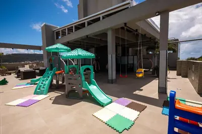 A área de jogos para crianças em Loft confortável em condominio com Piscina