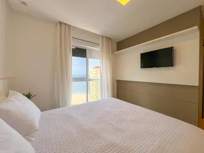 Uma cama ou camas num quarto em 4 suítes com vista e churrasqueira na quadra mar