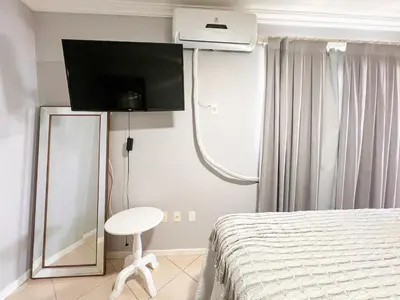 Uma televisão e/ou sistema de entretenimento em Amplo apartamento vista mar