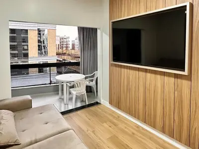 Uma televisão e/ou sistema de entretenimento em Apartamento Temporada Itapema Meia Praia