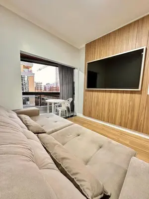 Uma televisão e/ou sistema de entretenimento em Apartamento Temporada Itapema Meia Praia