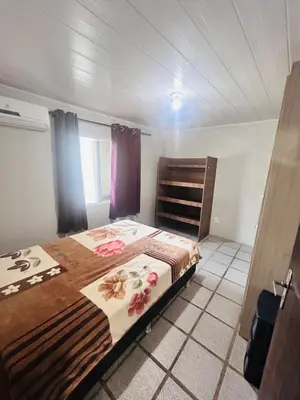 Uma cama ou camas num quarto em casa na vila da praia de Palmas