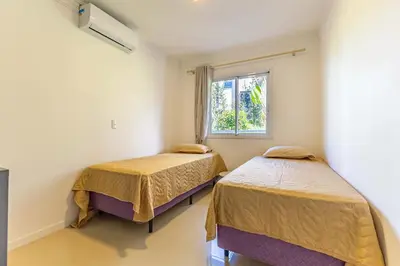 Uma cama ou camas num quarto em Amplo Apto a 150 Metros da Praia de Bombinhas