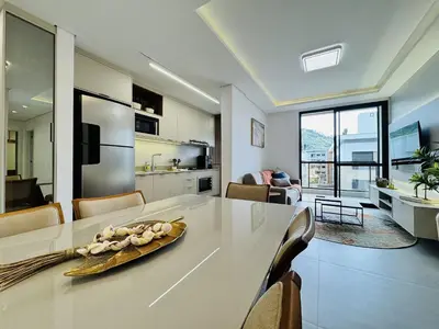 Uma televisão e/ou sistema de entretenimento em Oásis do Atlântico 303 A - Apartamento elegante na Praia de Palmas, em um condomínio clube completo.