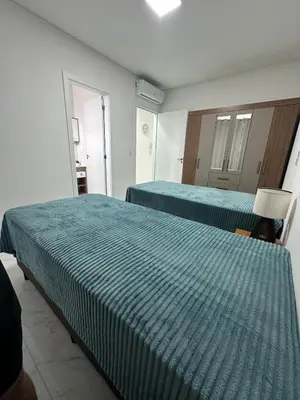 Uma cama ou camas num quarto em Apt 2 suites Novo 180M da Praia Completo