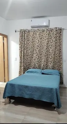 Uma cama ou camas num quarto em Quarto com frigobar e ar condicionado em Bombas