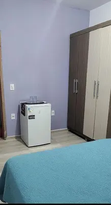 Uma cama ou camas num quarto em Quarto com frigobar e ar condicionado em Bombas