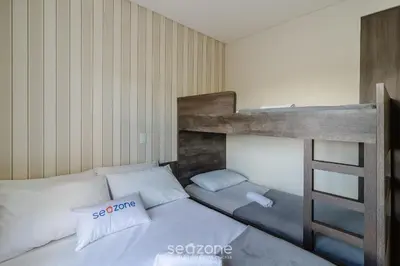 Uma cama ou camas num quarto em Apto c/ churrasq. e vista a 130m da Praia RSD0202