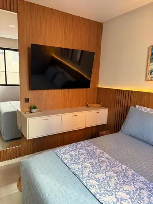 Uma cama ou camas num quarto em Apartamento moderno, a 200 metros da praia com pátio,piscina e churrasqueira privativa 2 vagas de garagem