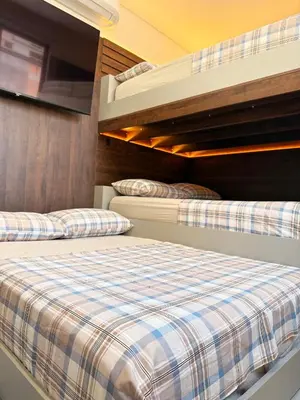 Uma cama ou camas num quarto em Apartamento moderno, a 200 metros da praia com pátio,piscina e churrasqueira privativa 2 vagas de garagem