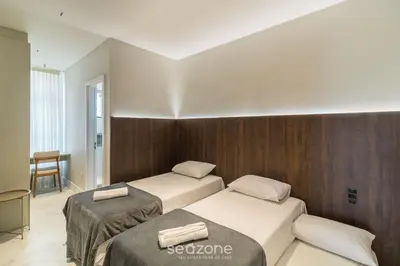 Uma cama ou camas num quarto em Aptos completos a poucos passos do mar em Perequê MTRs