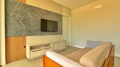 Uma televisão e/ou sistema de entretenimento em Apto Palmas do Arvoredo, apenas 400 metros do mar
