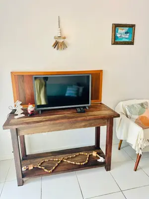 Uma televisão e/ou sistema de entretenimento em Incrível Apartamento vista mar a poucos passos da praia com 3 dormitórios