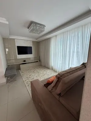 Uma televisão e/ou sistema de entretenimento em Apartamento 3 dormitórios Meia Praia SC