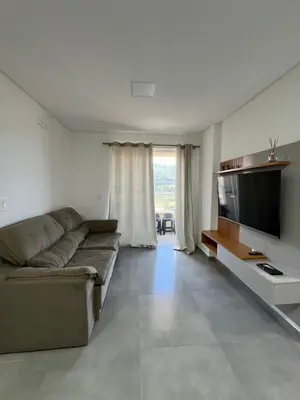 Uma televisão e/ou sistema de entretenimento em Apartamento novinho poucos minutos da praia