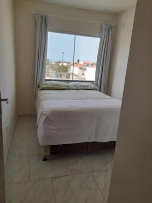 Uma cama ou camas num quarto em Apto em Tijucas compartilhado