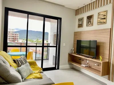 Uma televisão e/ou sistema de entretenimento em Apto PRAIA GRANDE 200M - MAR