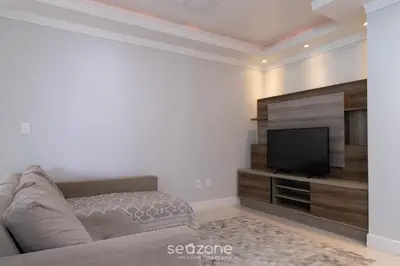 Uma televisão e/ou sistema de entretenimento em Apto prox a praia e com churrasqueira IBL103
