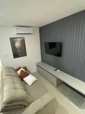 Uma televisão e/ou sistema de entretenimento em Apartment overlooking the ocean near the Central Beach
