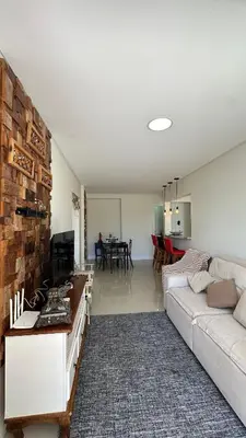 Uma área de estar em 02 Dorm. Com Churrasqueira