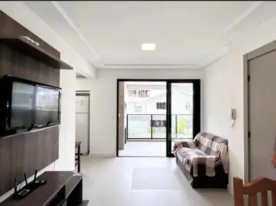 Uma televisão e/ou sistema de entretenimento em Apartamento na Praia de Palmas com 3 quartos