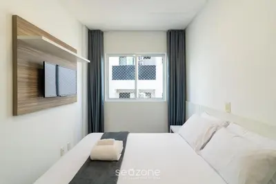 Uma cama ou camas num quarto em Apto 2 suítes e Churrasq. a 550m da Praia EBF0702