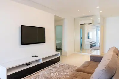 Uma televisão e/ou sistema de entretenimento em Apto 2 suítes e Churrasq. a 550m da Praia EBF0702